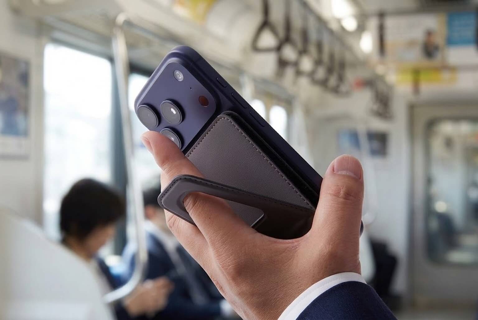通勤電車でスタンド脚に指を通してスマートフォンを保持